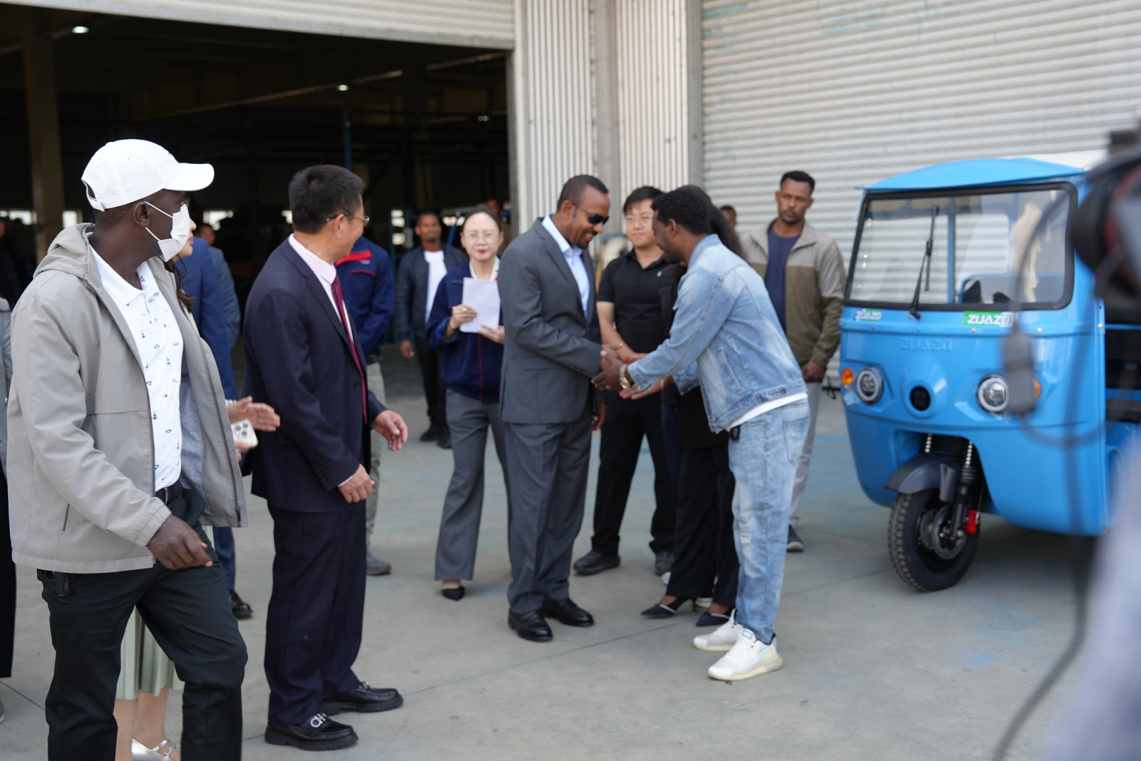 Prime Minister Abiy Ahmed views a ZIJAZO electric tricycle during the factory tour